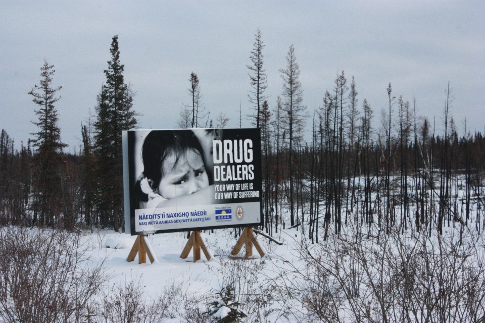 A billboard in Behchokǫ̀ reading "Drug dealers: your way of life is our way of suffering." Emily Blake/Cabin Radio