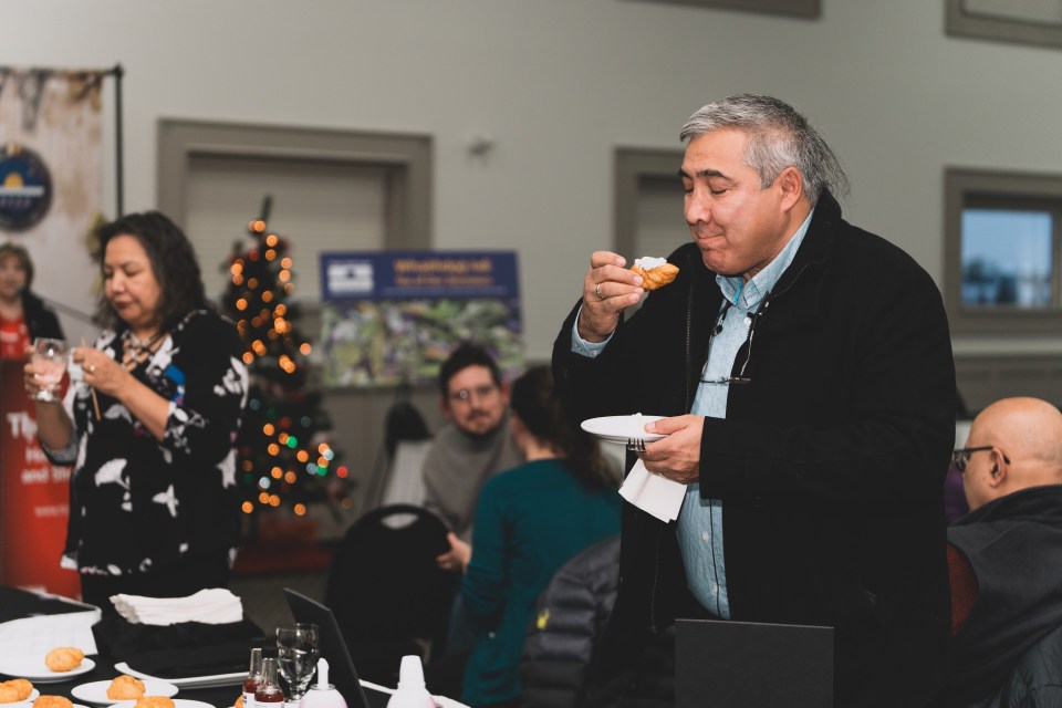 Chief of Behchokǫ̀ Clifford Daniels enjoys some bannock with the fireweed blossom syrup. Sarah Pruys/Tłı̨chǫ Government