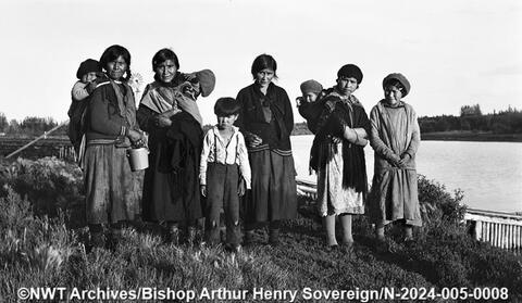 A group of Dene women and children standing near the river in Hay River, taken between 1932 and 1940. Bishop Arthur Henry Sovereign/NWT Archives
