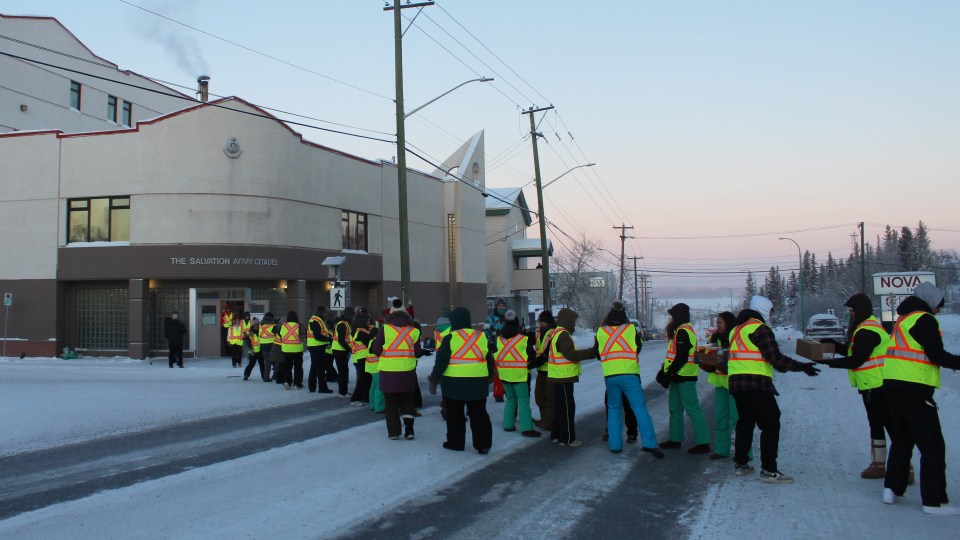 Students from École St Patrick High School created a human chain across Franklin Avenue to deliver food to the Salvation Army. Claire McFarlane/Cabin Radio