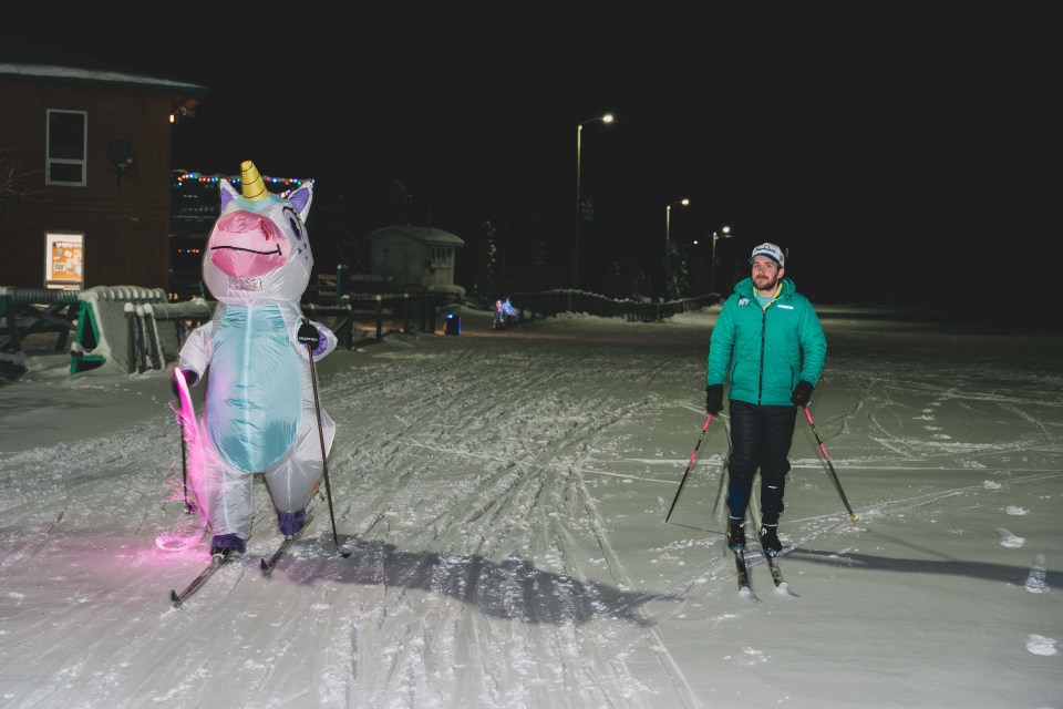 Maxwell McEachern, the ski club’s events director, guides unicorn Natasha McCagg on a short ski. Sarah Pruys/Cabin Radio