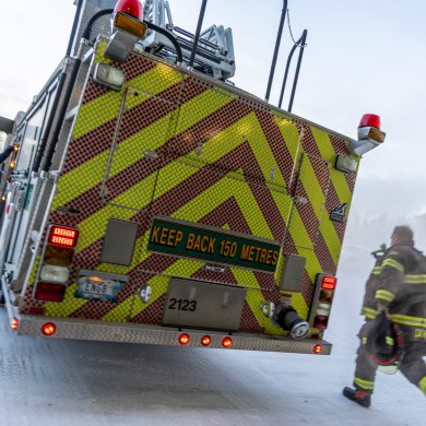 A firefighter races to an engine as a Yellowknife fire crew responds to a call on January 9, 2025. Ollie Williams/Cabin Radio
