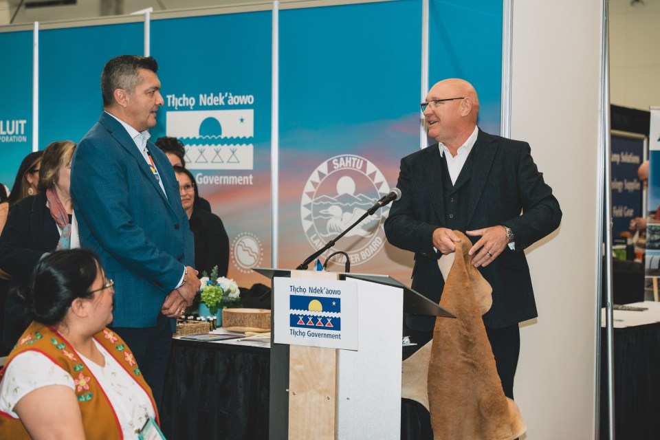 Fortescue's Warren Fish, right, presents a kangaroo skin to Tłı̨chǫ Grand Chief Jackson Lafferty at an agreement signing ceremony during Roundup 2025. Sarah Pruys/Tłı̨chǫ Government