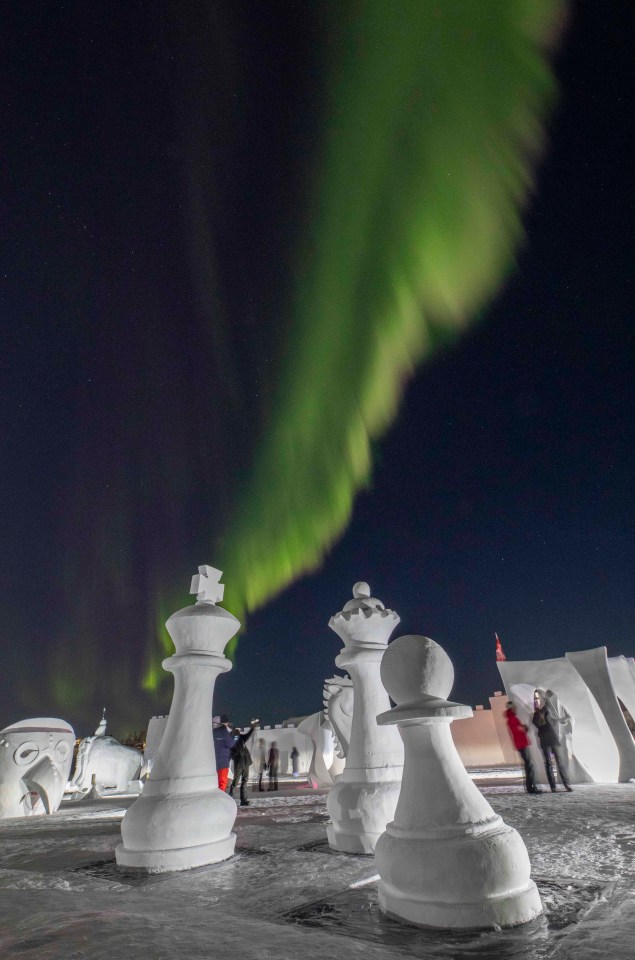 Snow carvings under the northern lights. FreezeFrame/Snowkings' Winter Festival