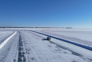 Vehicles travel on the ice road toward Dettah in March 2025. Sam Pitre/Cabin Radio