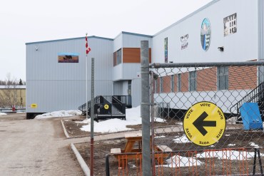 Signs direct voters to an advance polling location at the Mackenzie Mountain School in Norman Wells on Sunday. Claire McFarlane/Cabin Radio