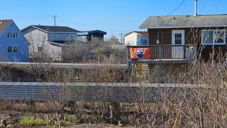 A flag brings some colour to an Inuvik neighbourhood in 2024. Ollie Williams/Cabin Radio