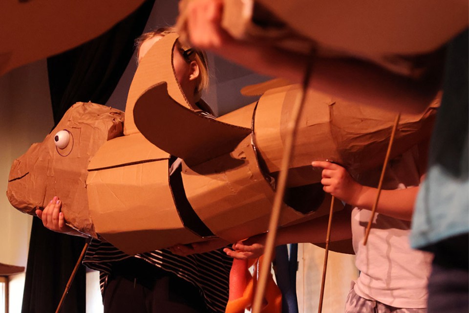 Cardboard puppet in the shape of a giant fish.