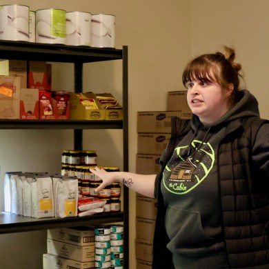 Katie Tetreault with supplies inside Norman Wells' food pantry. Aastha Sethi/Cabin Radio