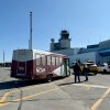 A hotel shuttle bus waits outside Yellowknife Airport in June 2025. Ollie Williams/Cabin Radio