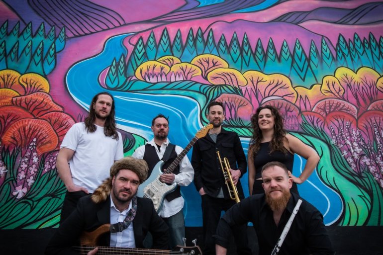 Yukon pop-funk band Major Funk poses in front of a mural in a photo published by Folk on the Rocks.