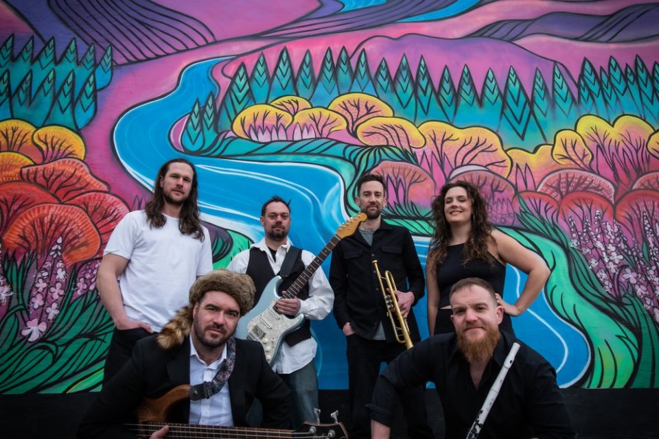 Yukon pop-funk band Major Funk poses in front of a mural in a photo published by Folk on the Rocks.