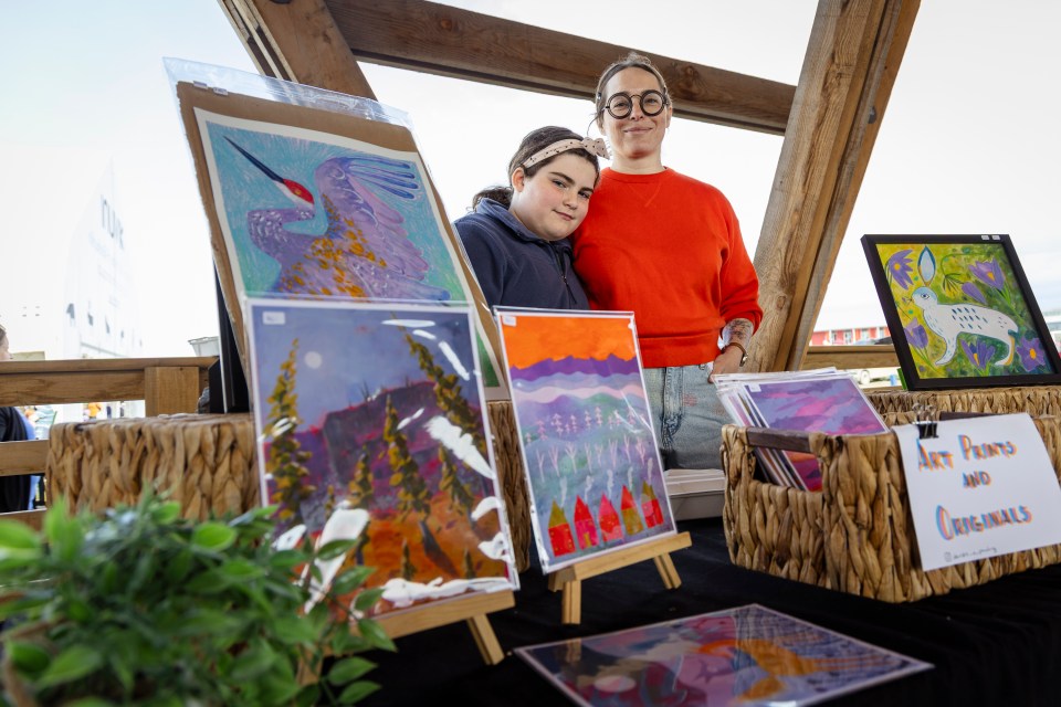 Deirdre Dagar, right, at her art stall with daughter Ophelia during Inuvik's Arctic Market on June 21, 2025. Ollie Williams/Cabin Radio