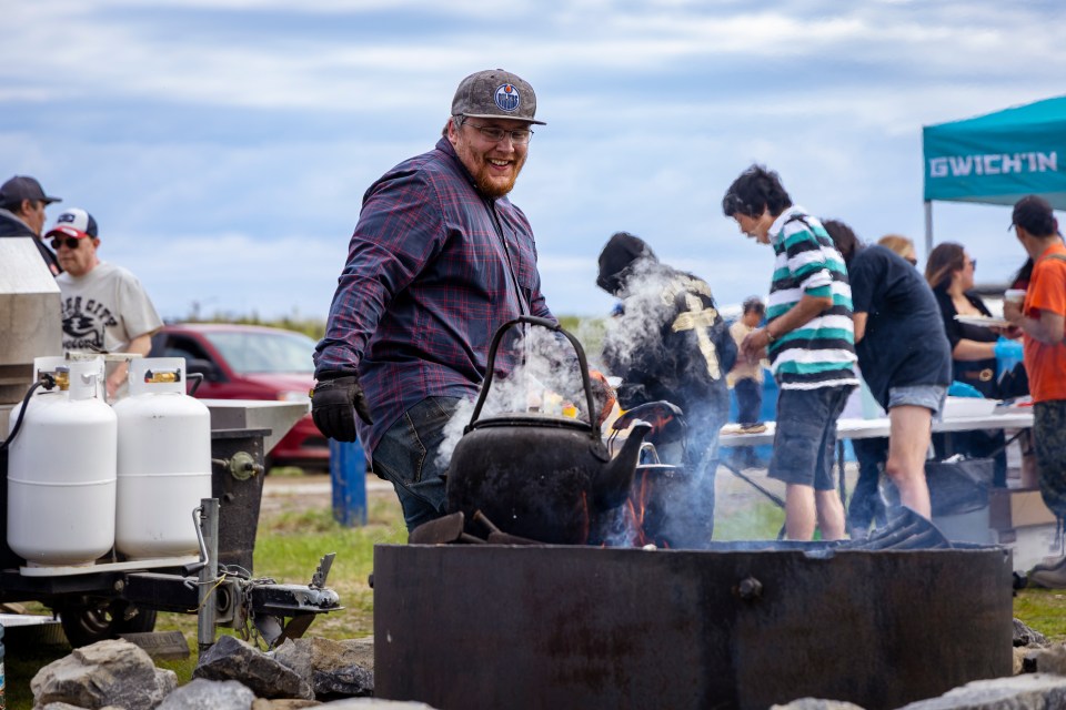 Kelly McLeod boils tea during Inuvik's National Indigenous Peoples Day celebrations on June 21, 2025. Ollie Williams/Cabin Radio