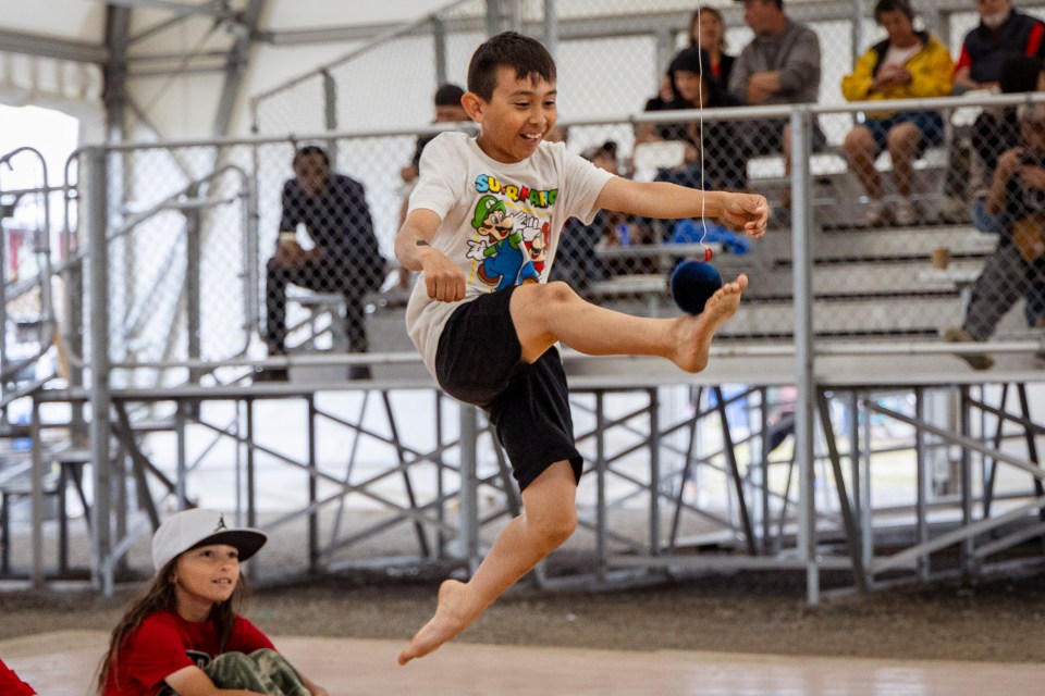 A demonstration of one-foot high kick at Inuvik's National Indigenous Peoples Day celebrations on June 21, 2025. Ollie Williams/Cabin Radio
