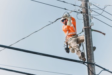 A power technician at work in June 2025. Sarah Pruys/Cabin Radio
