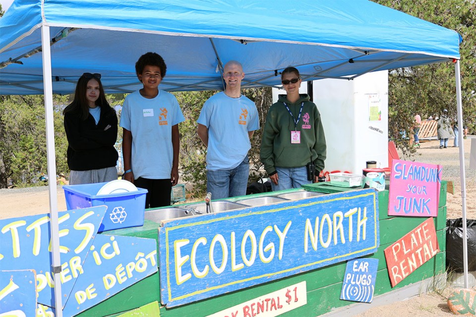 Group of volunteers standing behind the Ecology North booth.