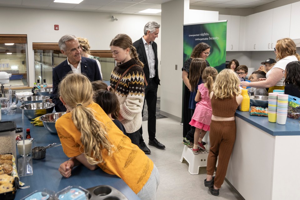 Mark Carney and NWT Premier RJ Simpson join a baking session at Fort Smith's community centre. Ollie Williams/Cabin Radio