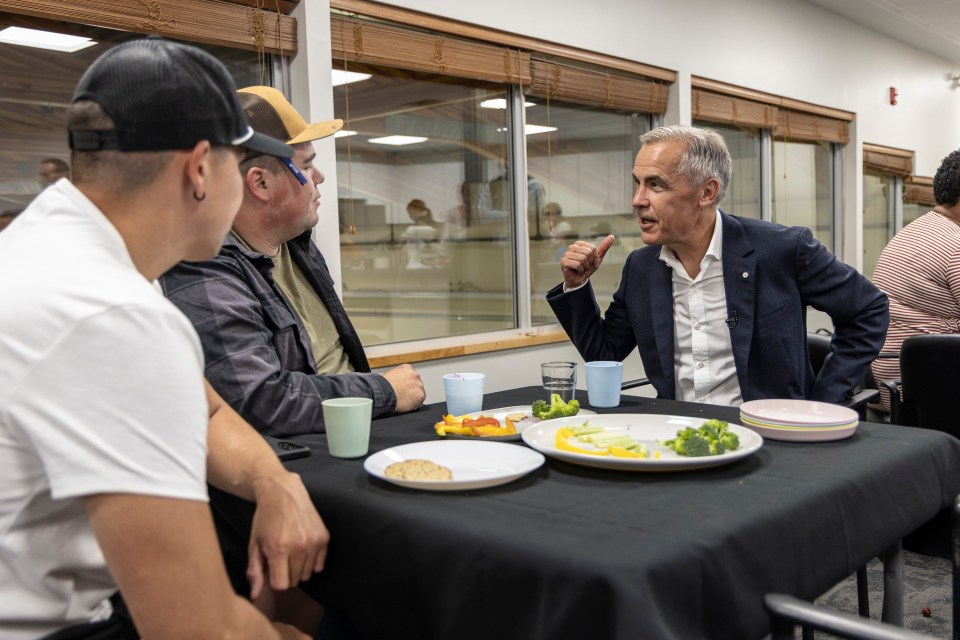 Mark Carney in discussion with Fort Smith resident Jeremy Beamish about the condition of Joseph Burr Tyrrell School, where his father was once the principal. Ollie Williams/Cabin Radio