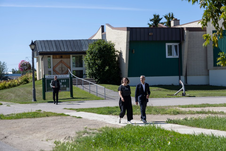 Mark Carney and NWT MP Rebecca Alty, the Crown-Indigenous relations minister, walk past Fort Smith's Northern Life Museum. Ollie Williams/Cabin Radio