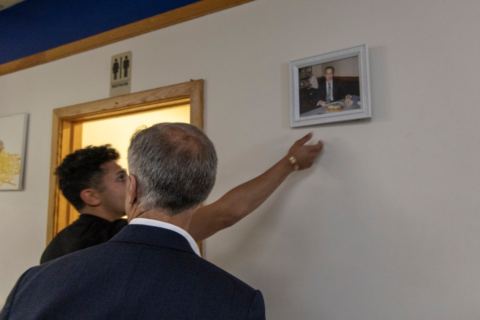 Mark Carney spots a photo of his last visit to Berro's, Fort Smith's pizza parlour. Ollie Williams/Cabin Radio
