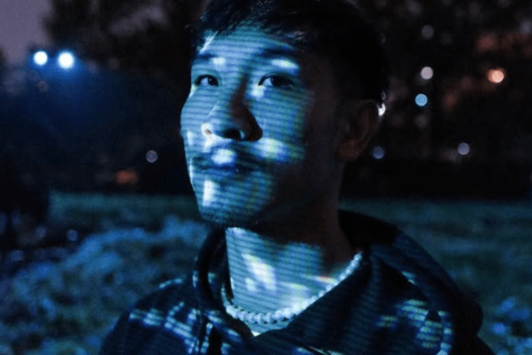 A picture of Jonny Vu with blue and white light over his face.