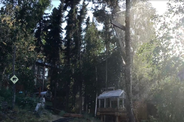 A sprinkler system at Hearne Lodge Lake deploying a moisture dome in the face of an oncoming wildfire. Photo: Submitted