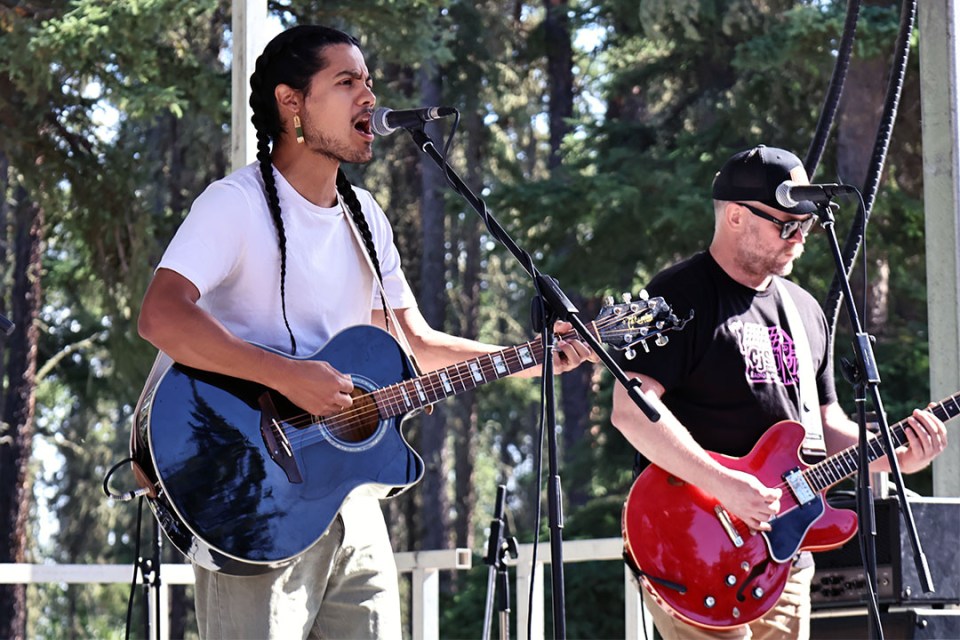 2 men with guitars perform on stage.