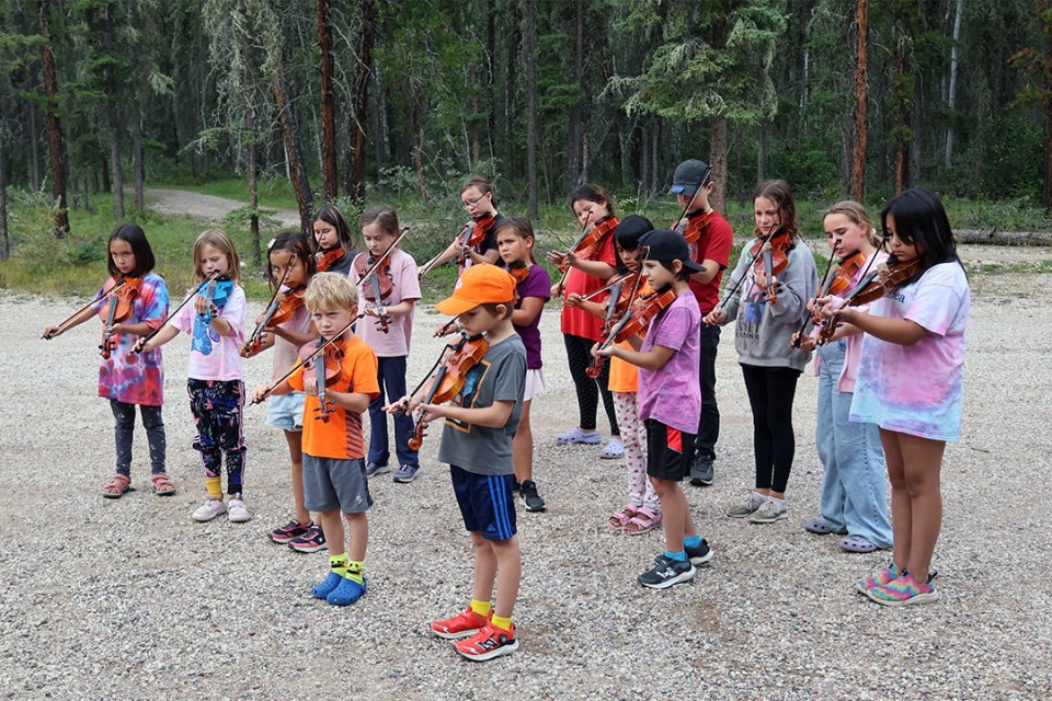 Group of children playing fiddles.