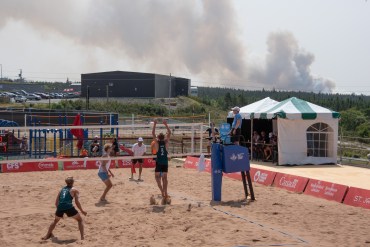The smoke plume from a wildfire is seen behind a beach volleyball contest at the Canada Games on August 11, 2025. Penny Rogers/Canada Games