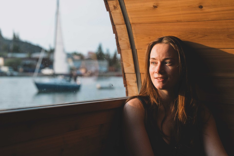A sailboat passes by the Arctic Duchess' summer spot on Yellowknife Bay. Sarah Pruys/Cabin Radio