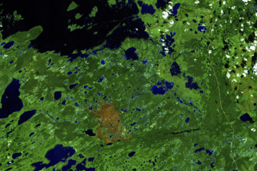 The burn area of fire ZF048 is seen to the southwest of Whatì in a Sentinel-2 false colour satellite image from August 23, 2025.