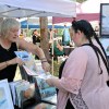 A vendor shows a woman her art.