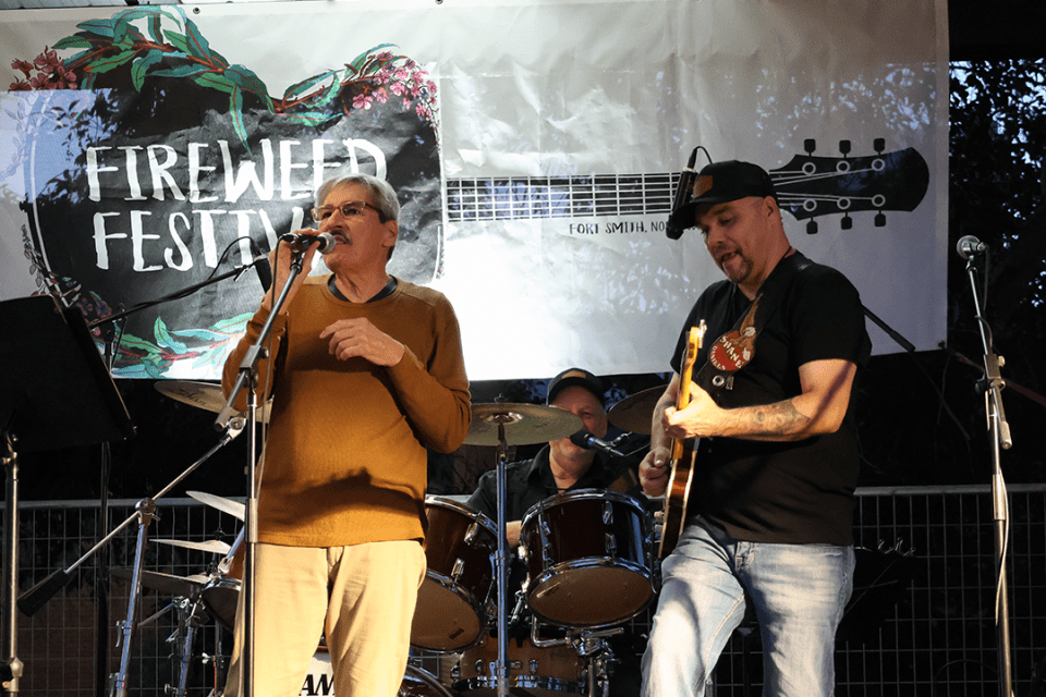 Man singing accompanied by guitar and drums