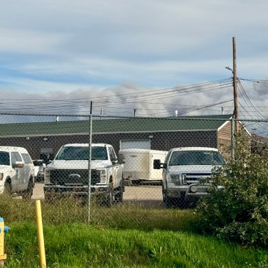 Smoke from fire FS014 is seen behind a wildfire operations compound in Fort Simpson. Photo: Lynn Canney