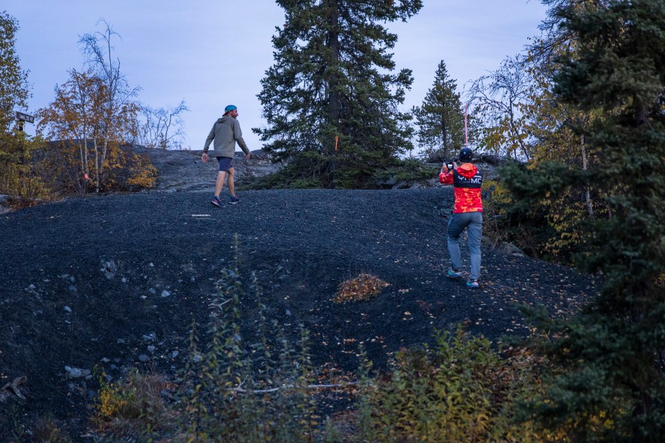 Herb Mathisen, left, completes a lap of the course while organizer Mike Lee takes a photo. Ollie Williams/Cabin Radio
