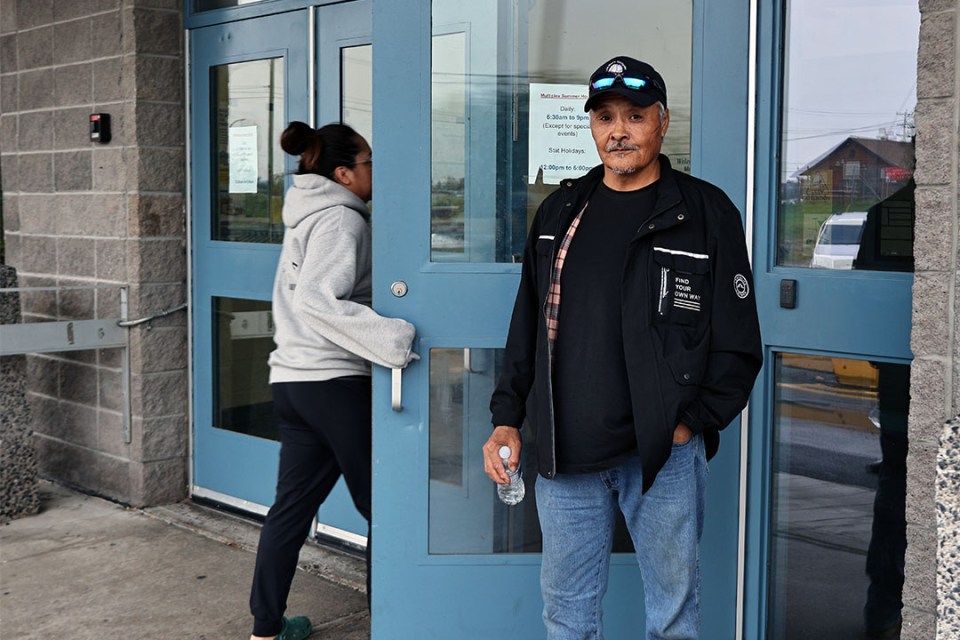 Man stands in front of doors of multiplex centre