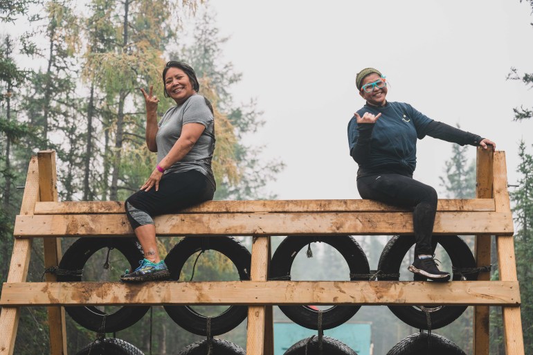 Muddy contenders atop an obstacle at the 2025 Yellowknife Mud Run. Sarah Pruys/CIBC Run for Our Lives