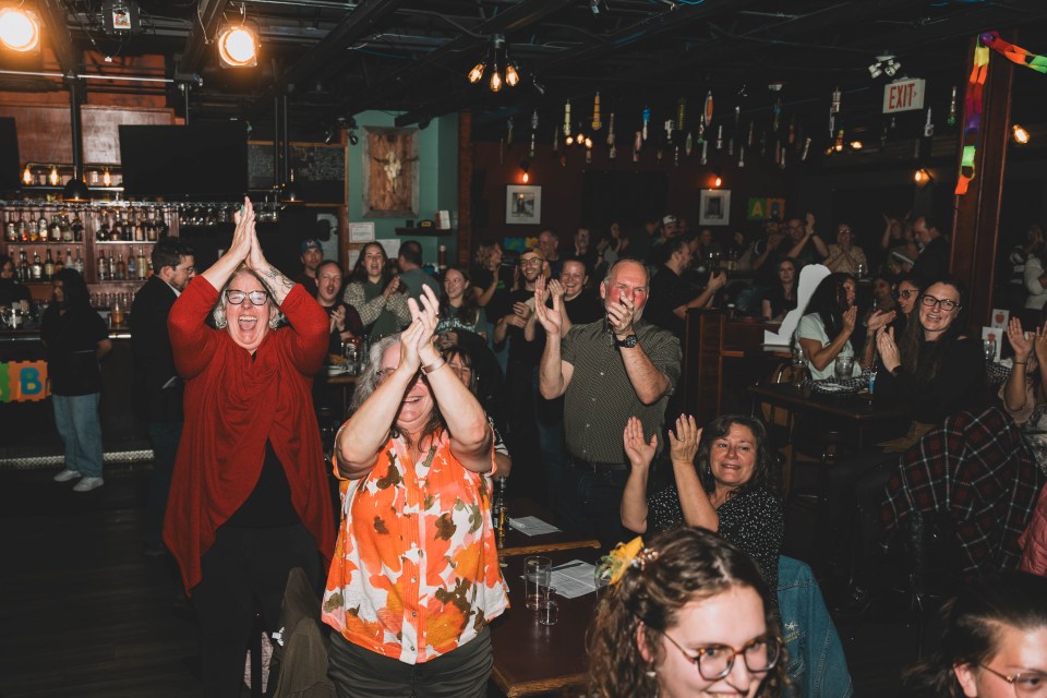 The crowd cheers as Jacki McKinnon spells the championship word – Deninu Kųę́, without the accents – properly to win the game. Sarah Pruys/Cabin Radio
