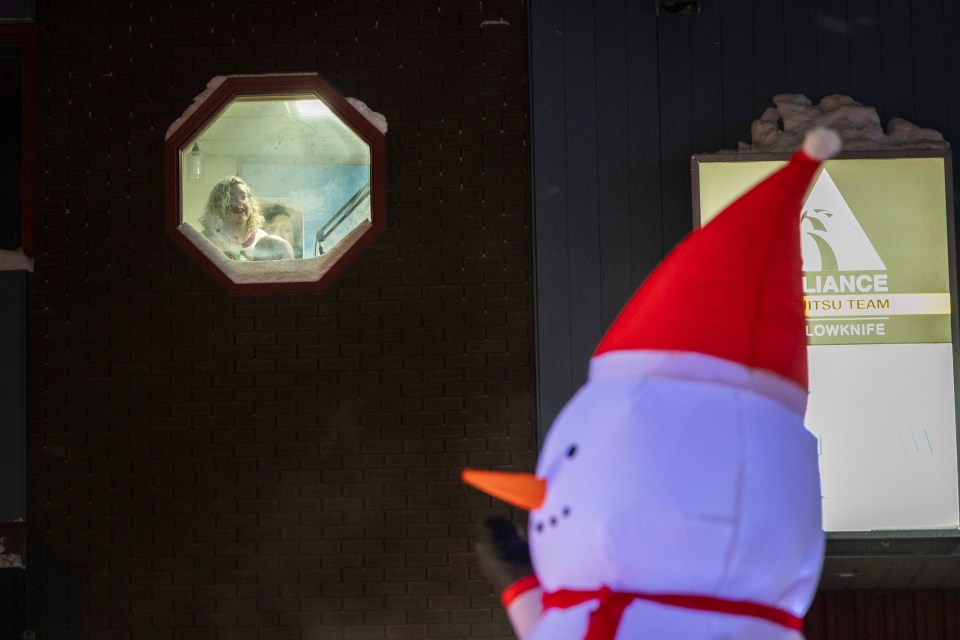 Cabin Radio's Michelle MacDonald watches the parade while on air from Studio One in downtown Yellowknife. Ollie Williams/Cabin Radio