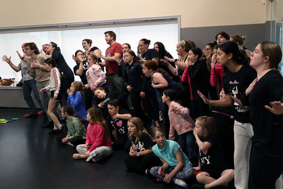 Group of adults and children perform during a ballet rehearsal