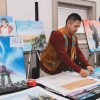 Darrell Chocolate wraps up a painting that just sold in 2024. Sarah Pruys/Tłı̨chǫ Arts
