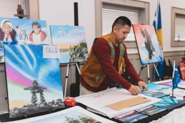 Darrell Chocolate wraps up a painting that just sold in 2024. Sarah Pruys/Tłı̨chǫ Arts