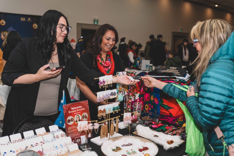A patron purchases something from artist Roxanne Kotchilea's booth in 2024. Sarah Pruys/Tłı̨chǫ Arts