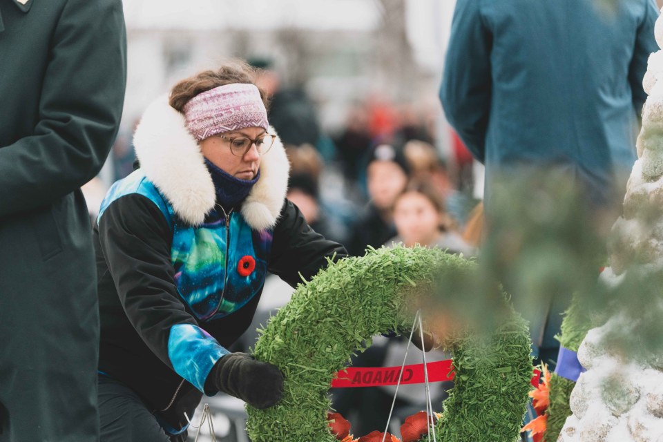 MP and Minister of Crown-Indigenous Relations Rebecca Alty lays a wreath at the cenotaph. Sarah Pruys/Cabin Radio