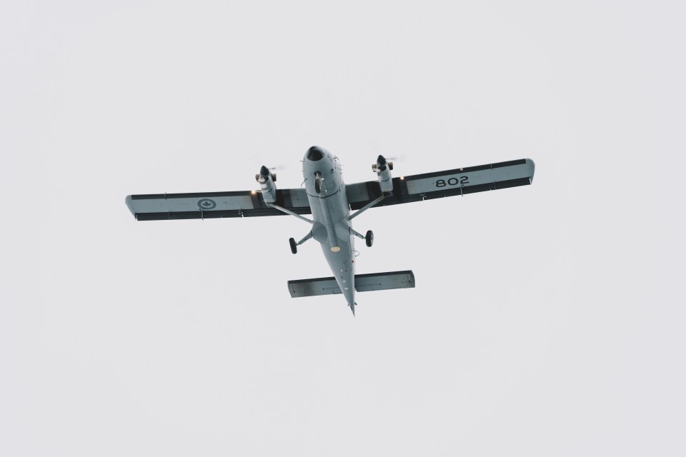 A plane completes a fly-over of the 2025 Remembrance Day ceremony. Sarah Pruys/Cabin Radio