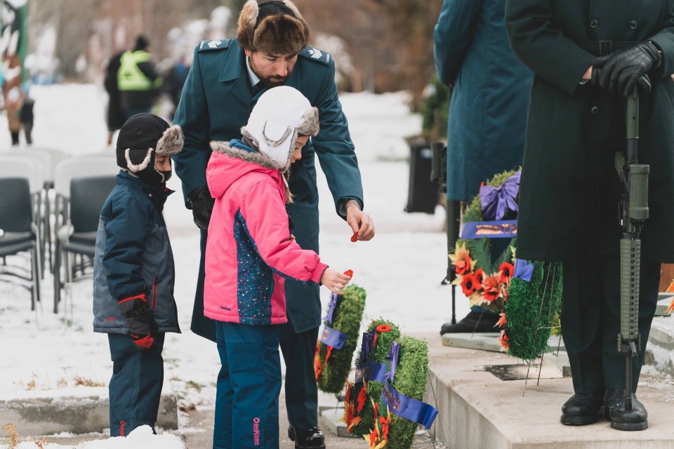 Children lay their poppies at the cenotaph on Remembrance Day. Sarah Pruys/Cabin Radio