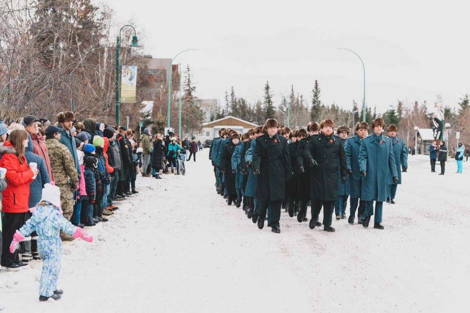 Members of the military march along 49th Avenue – also called Veterans Memorial Drive – at the start of the 2025 Remembrance Day ceremony. Sarah Pruys/Cabin Radio