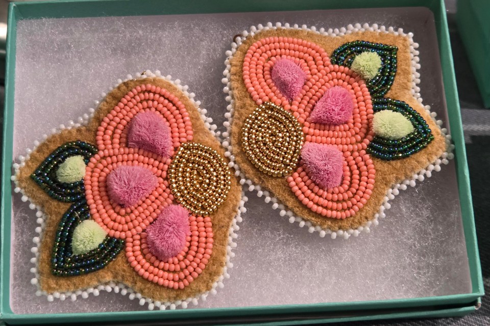 "Nature guided every part of this design. The softness of the pink tufted caribou hair was inspired by the gentle hues of northern skies at sunrise and the delicate textures found in moss, blossoms, and animal fur shaped by the land. The movement of the tufts reflects how grasses and wild plants sway in the wind, full of quiet life. The 24kt gold beads echo the way sunlight glimmers across snow, water, and stone, adding warmth and contrast. Together, these elements honor the natural world, transforming its colors, textures, and light into a wearable expression of balance, respect, and beauty," writes Blake. These earrings are called Blush of the North.