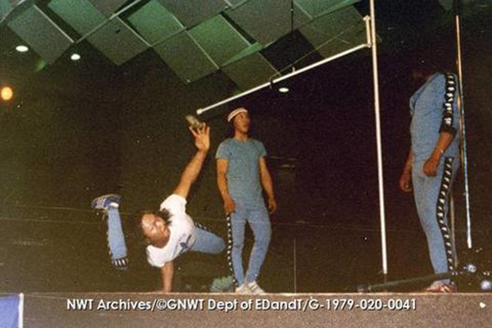 Larry Dick of Aklavik, John Tiapanak of Baker Lake and William Day of Reindeer Station perform the one-hand-reach as a demonstration at the Montreal Olympics. NWT Archives/Northwest Territories. Department of Economic Development and Tourism fonds/G-1979-020: 0041